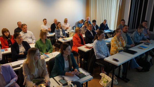 osoby w ławkach na szkoleniu