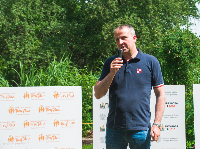 1 osoba stoi podczas pikniku z mikrofonem.