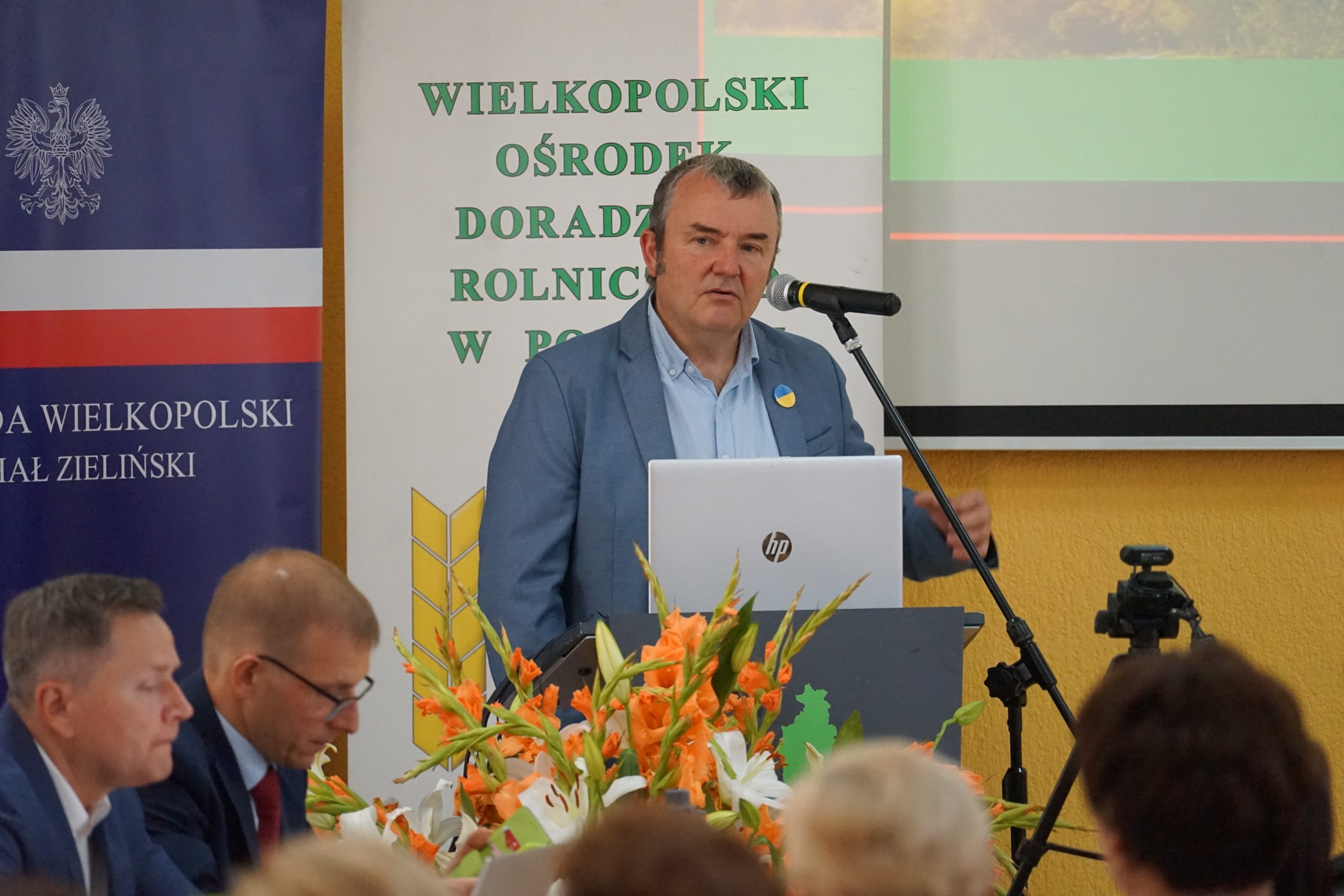 1 osoba stoi przy mównicy.