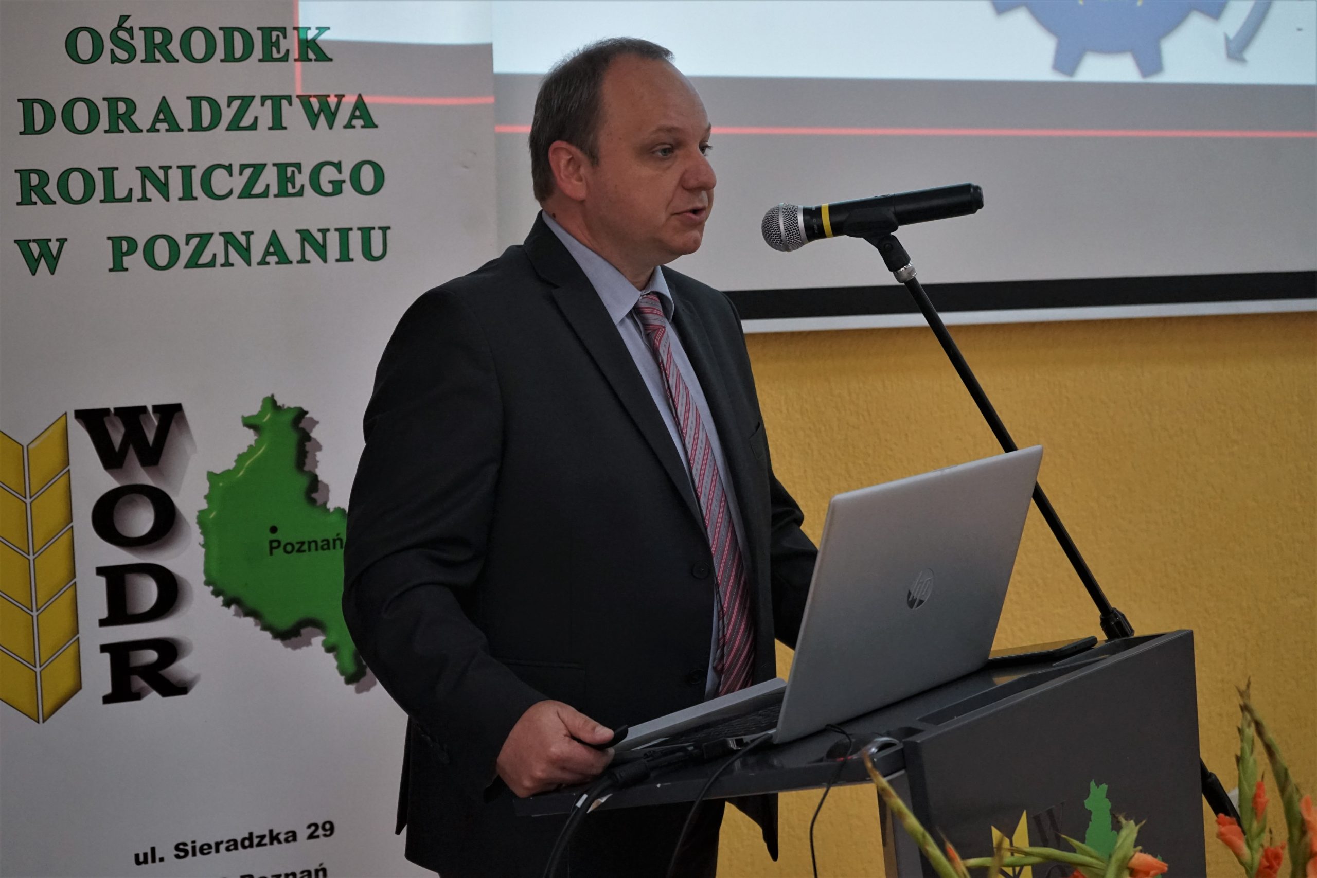1 osoba stoi przy mównicy.