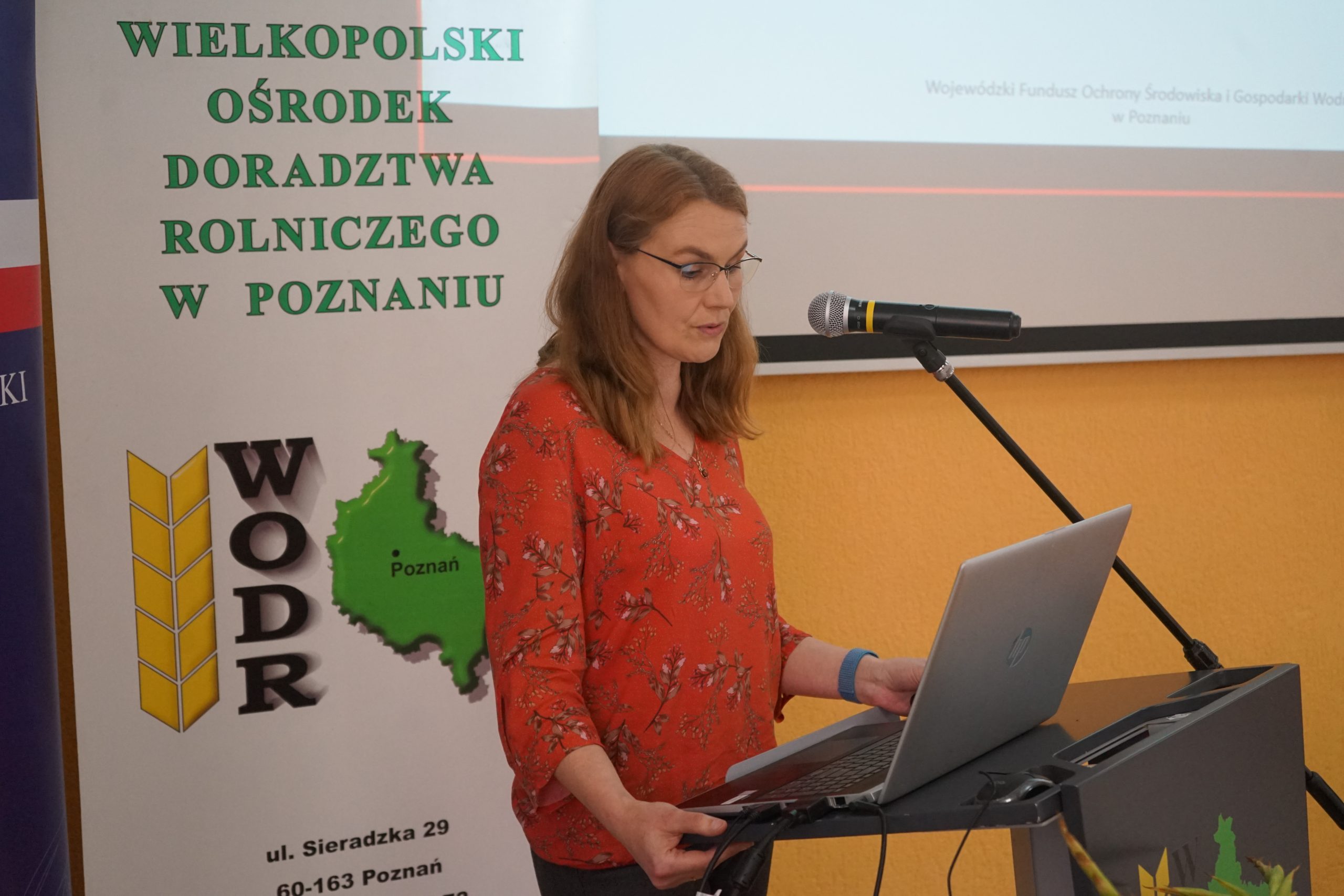 1 osoba stoi przy mównicy.