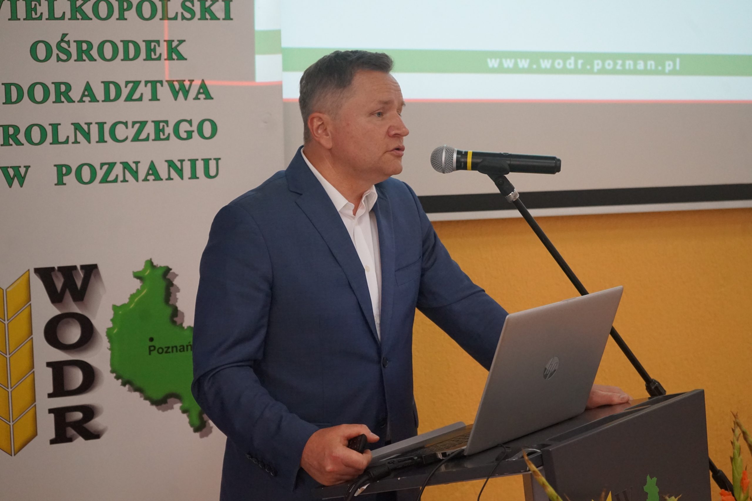 1 osoba stoi przy mównicy.