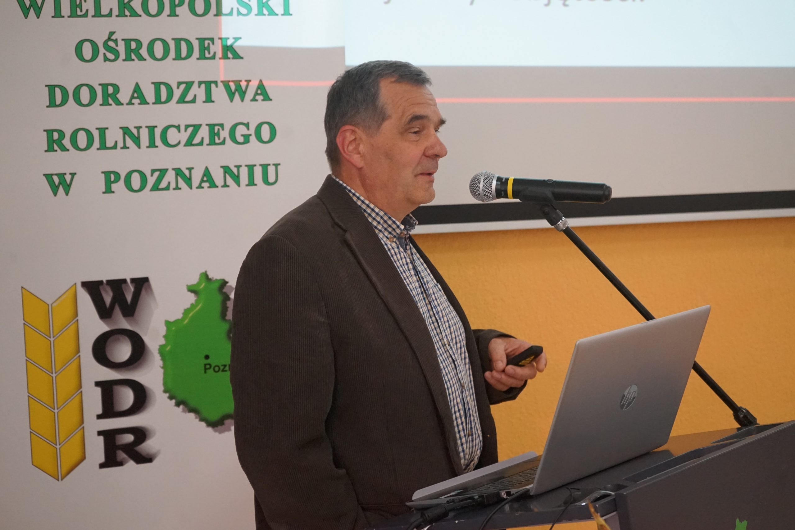 1 osoba stoi przy mównicy.