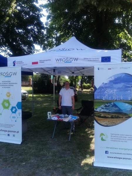 1 osoba stoi przy stoisku wystawienniczym.