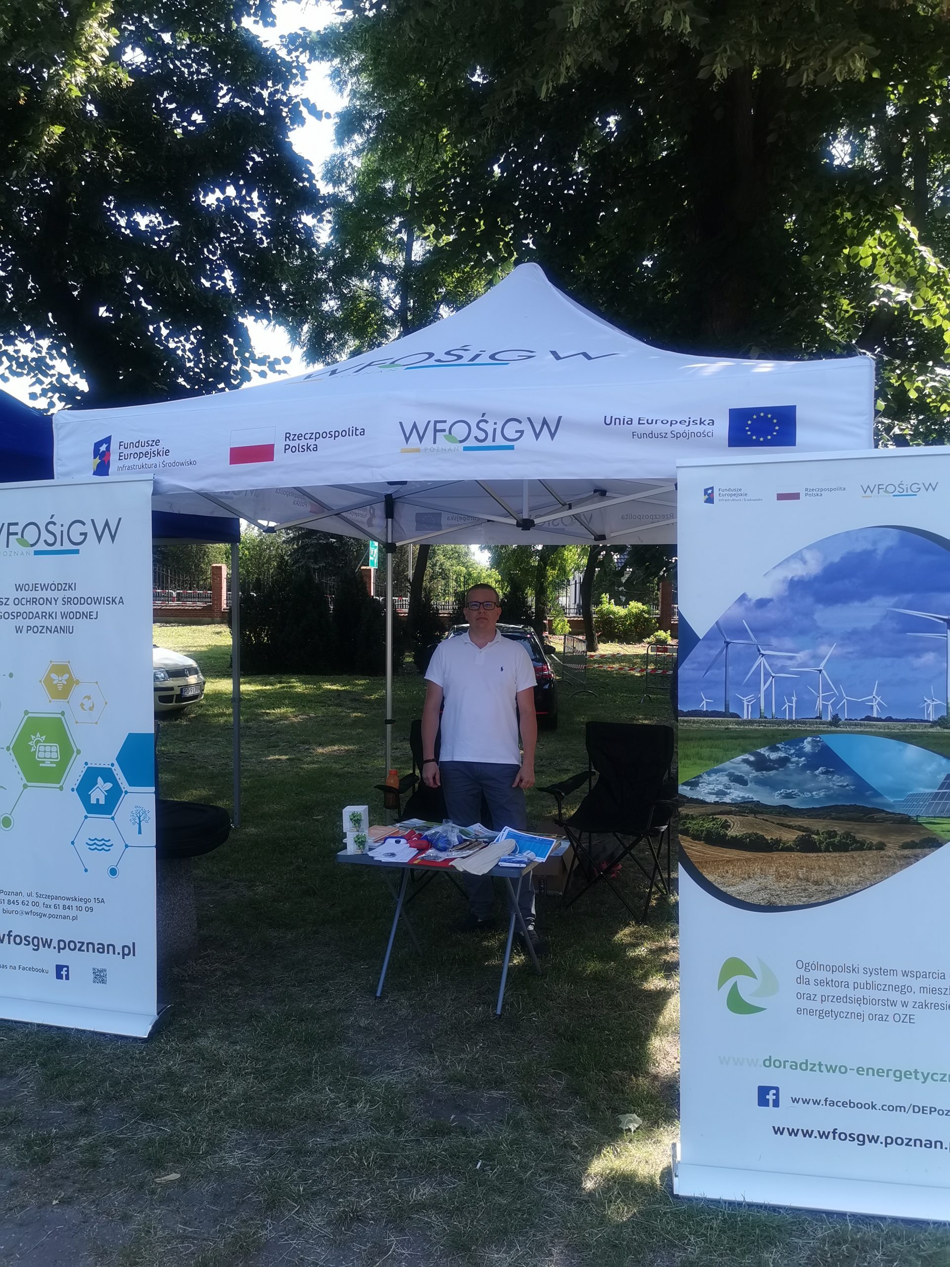 1 osoba stoi przy stoisku wystawienniczym.