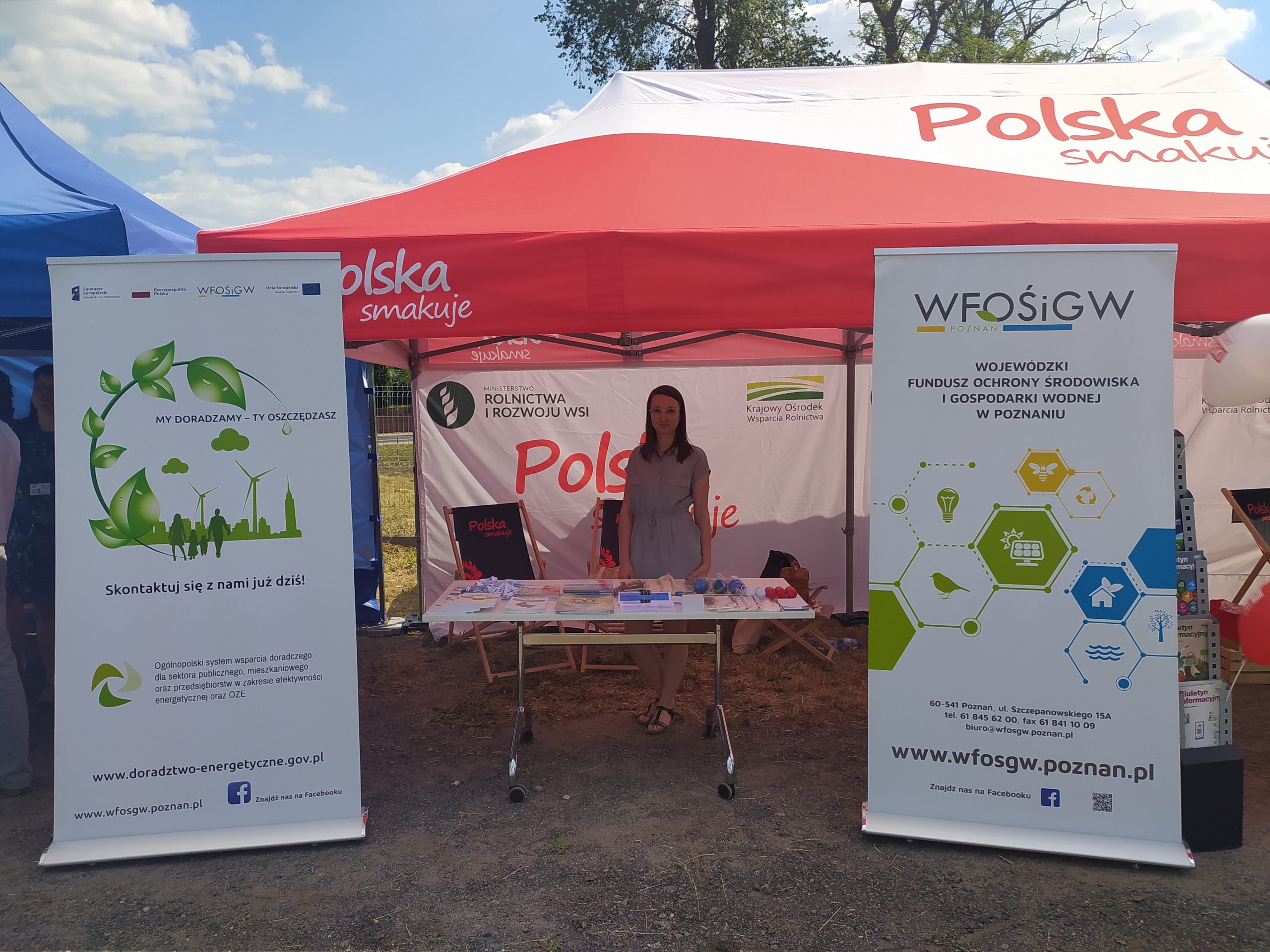 1 osoba stoi przy stoisku wystawienniczym.