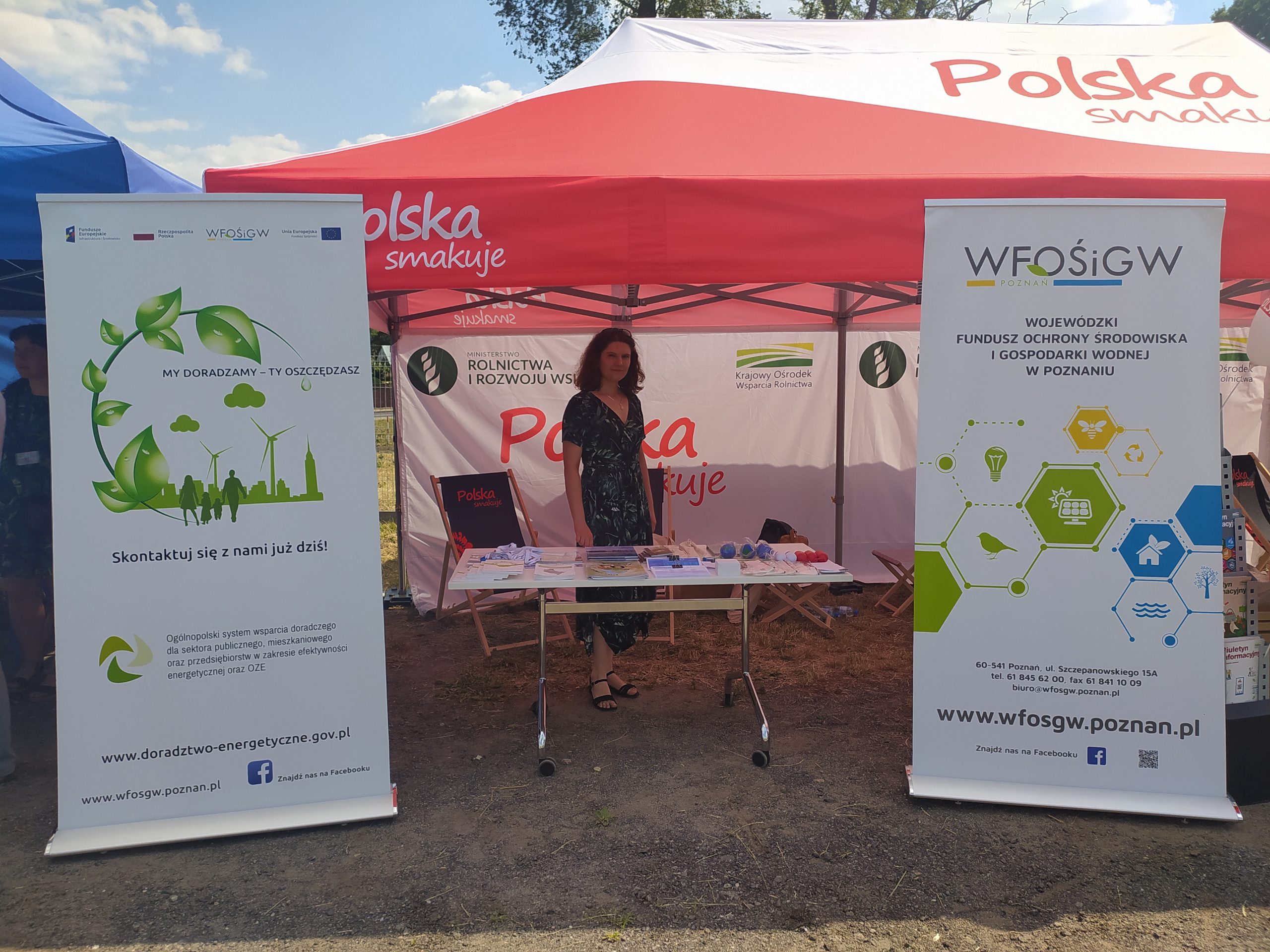 1 osoba stoi przy stoisku wystawienniczym.