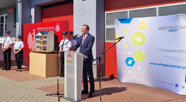 1 osoba stoi przy mównicy.