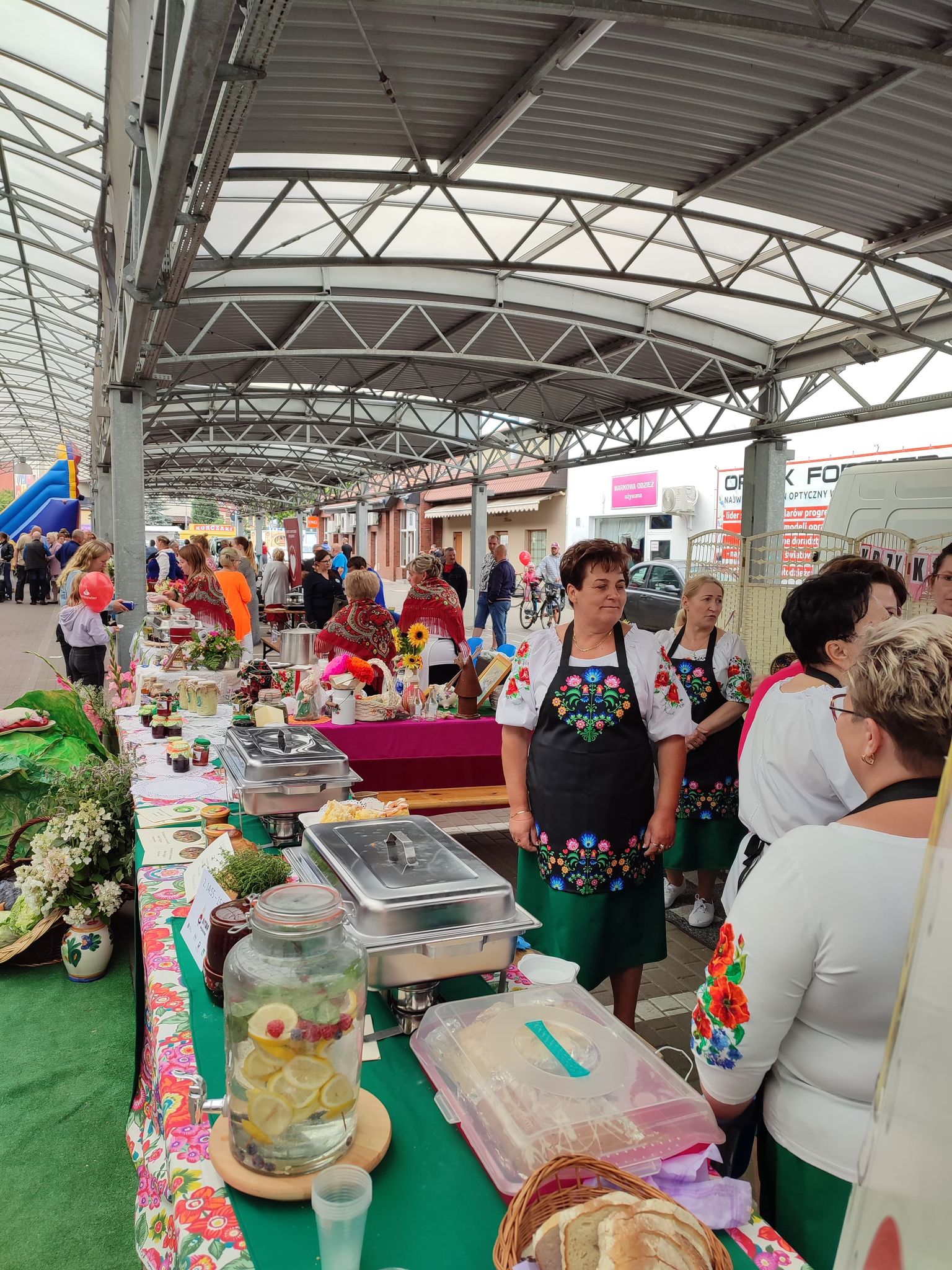Ludzie na festynie przy stoiskach wystawienniczych.