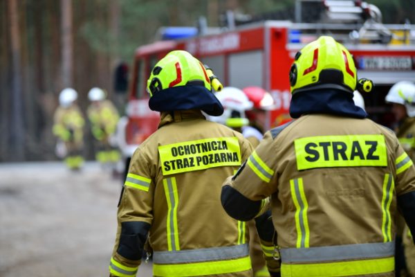 Strażacy podczas akcji na drodze.