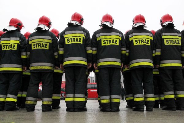 Strażacy stojący w rzędach.