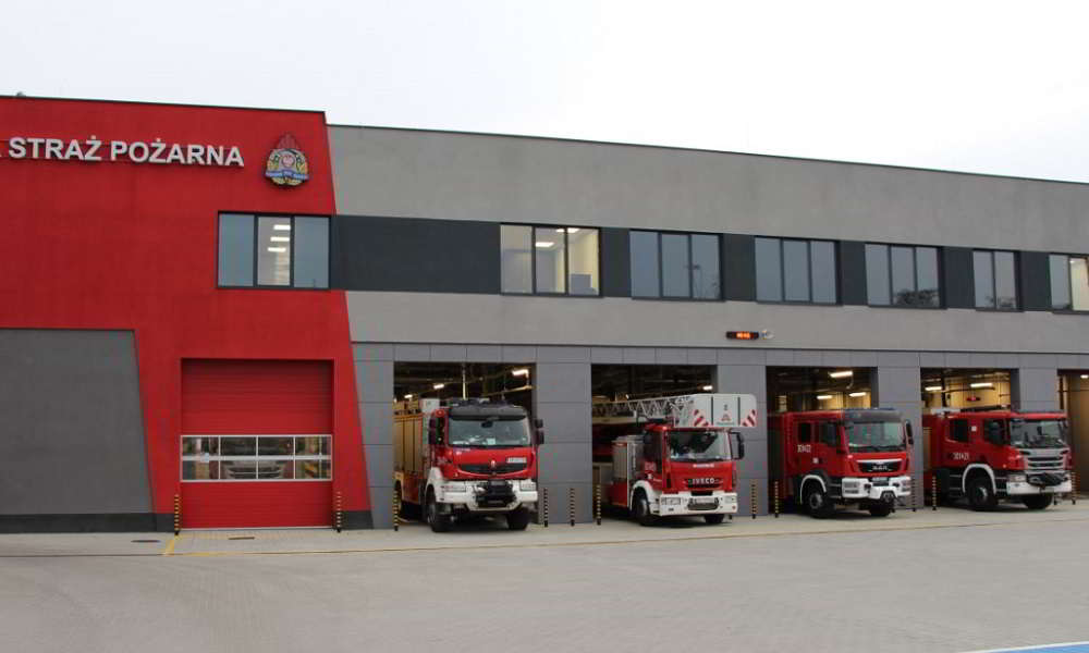 Wozy strażackie przed komendą straży pożarnej.
