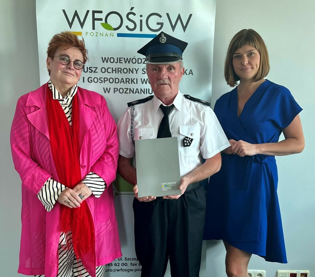 3 osoby stoją na tle ściany.