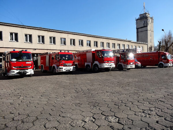 Wozy strażackie na tle remizy.