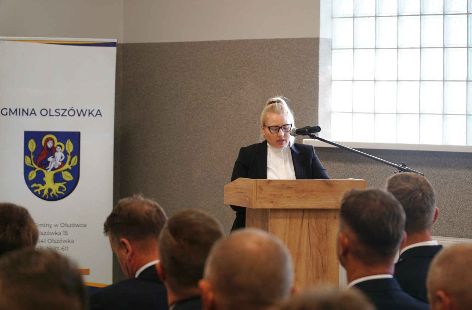 1 osoba stoi przy mównicy.