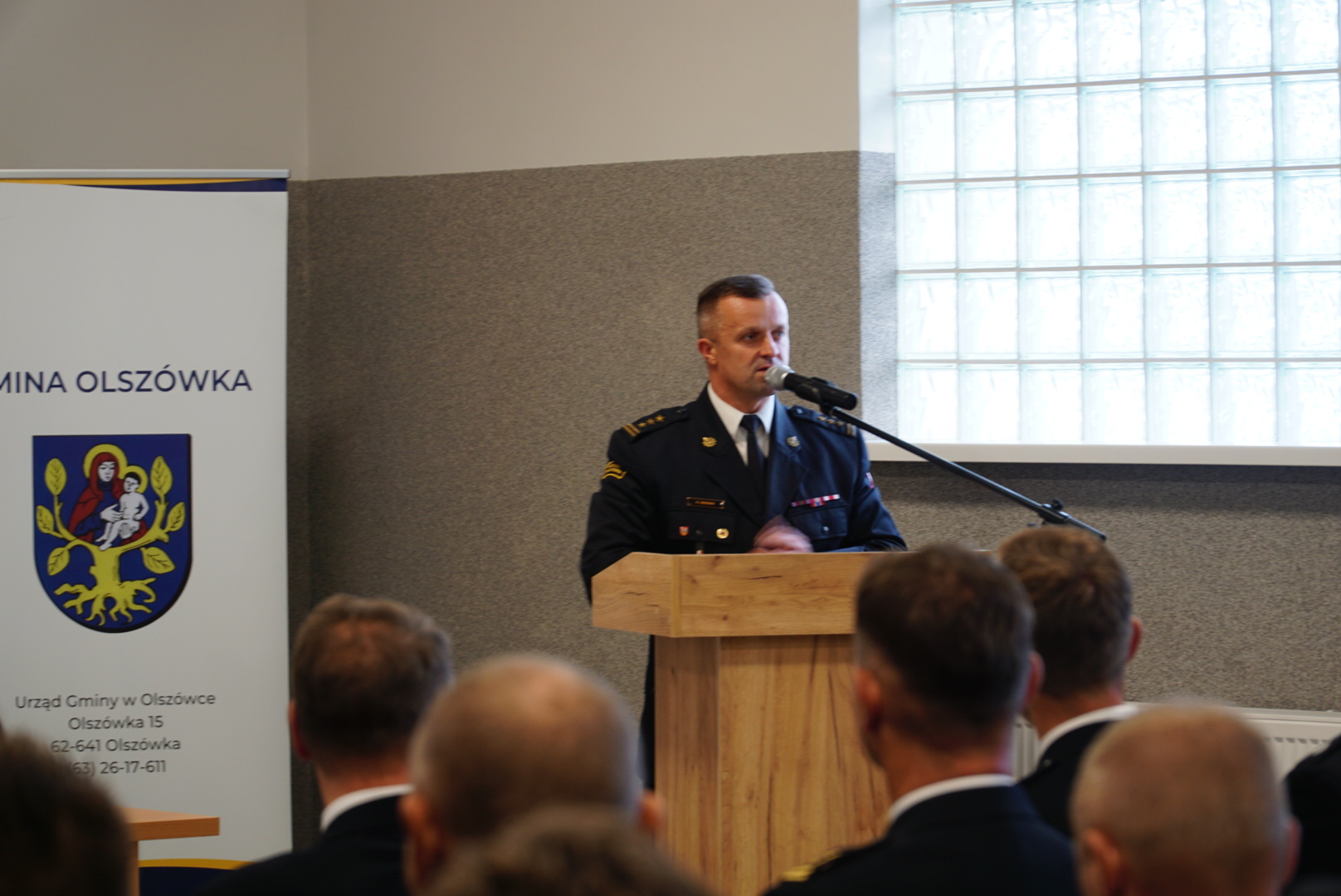 1 osoba stoi przy mównicy.