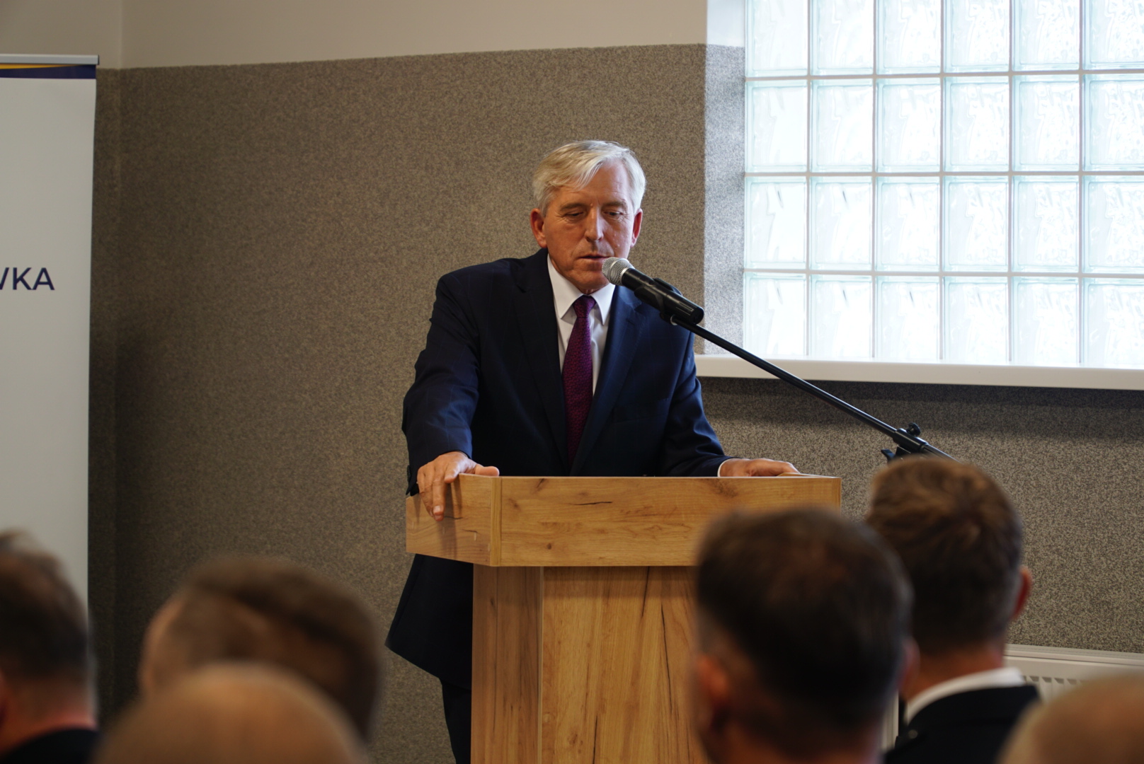 1 osoba stoi przy mównicy.