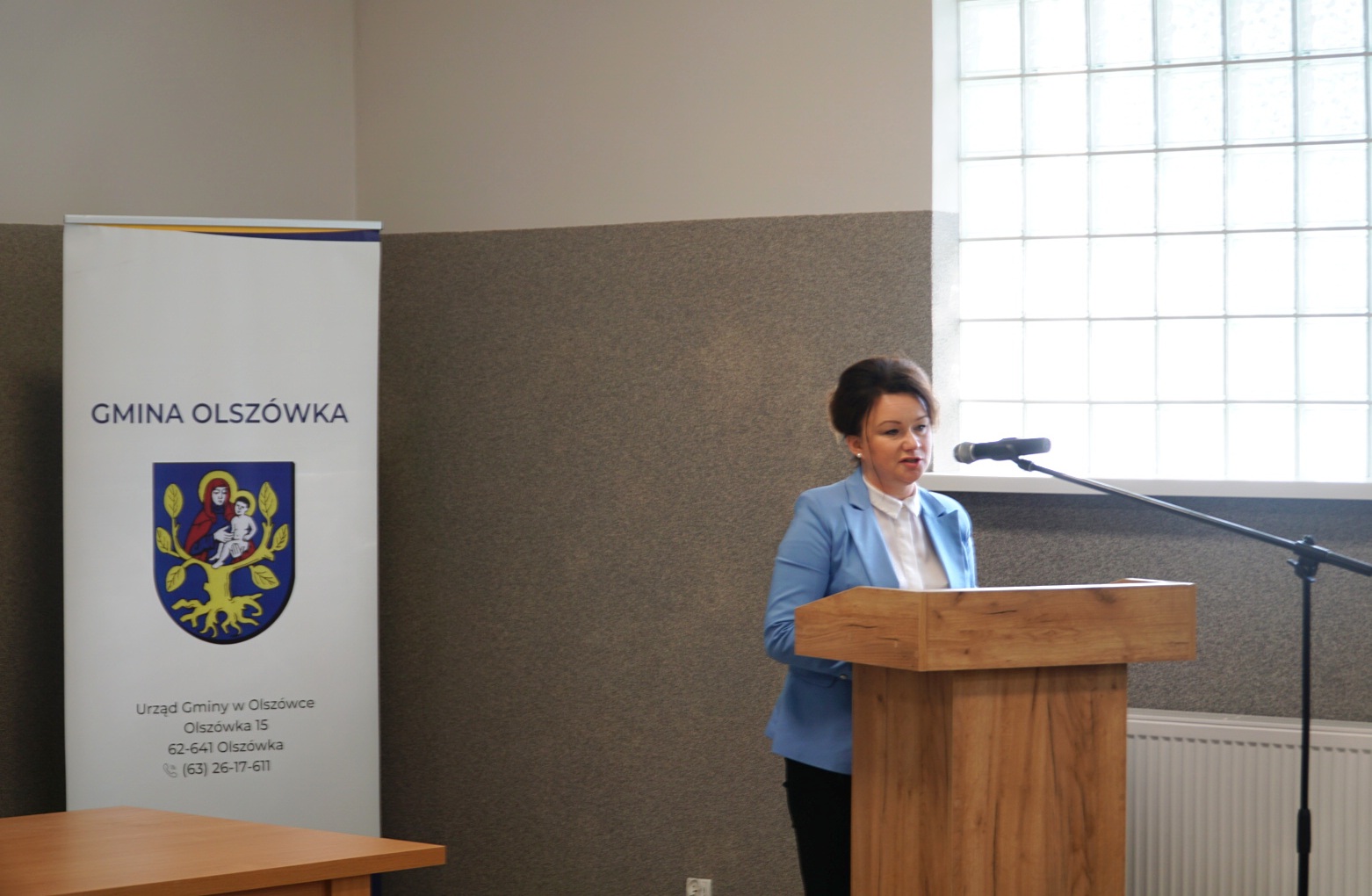 1 osoba stoi przy mównicy.