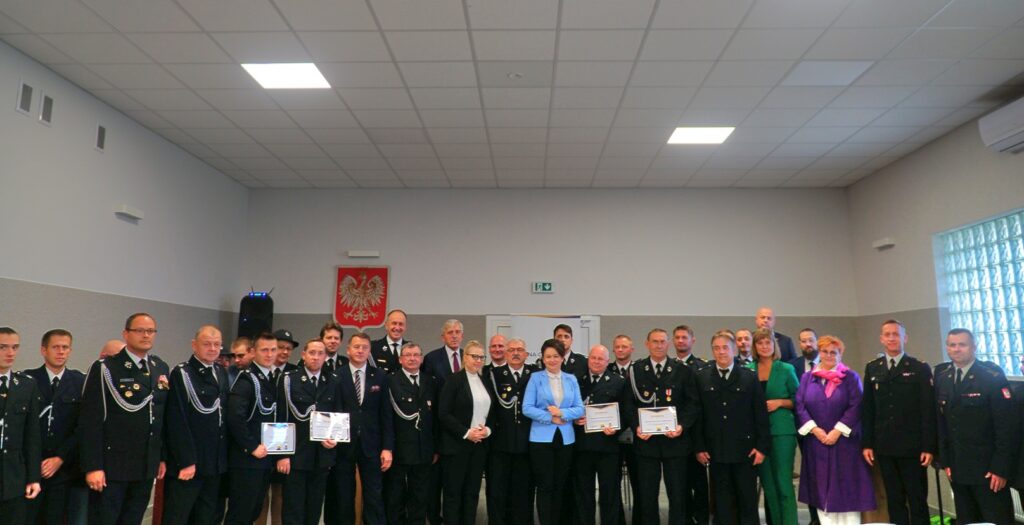 Duża grupa ludzi stoi w pomieszczeniu.