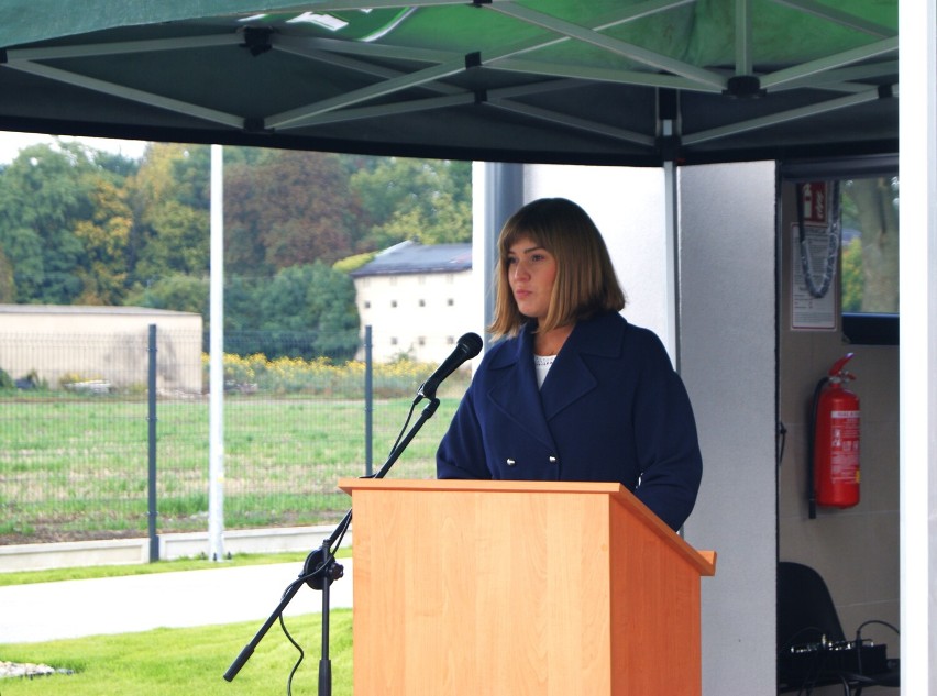 1 osoba stoi przy mównicy.