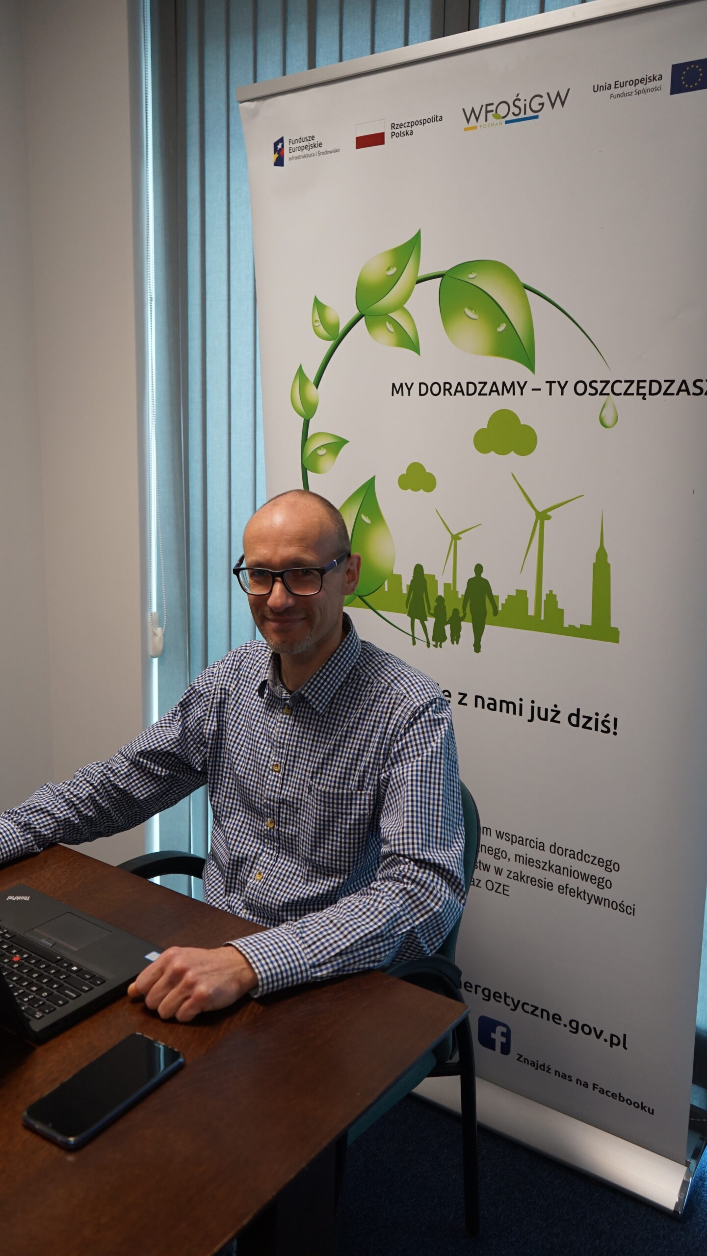 1 osoba siedzi przy biurku.