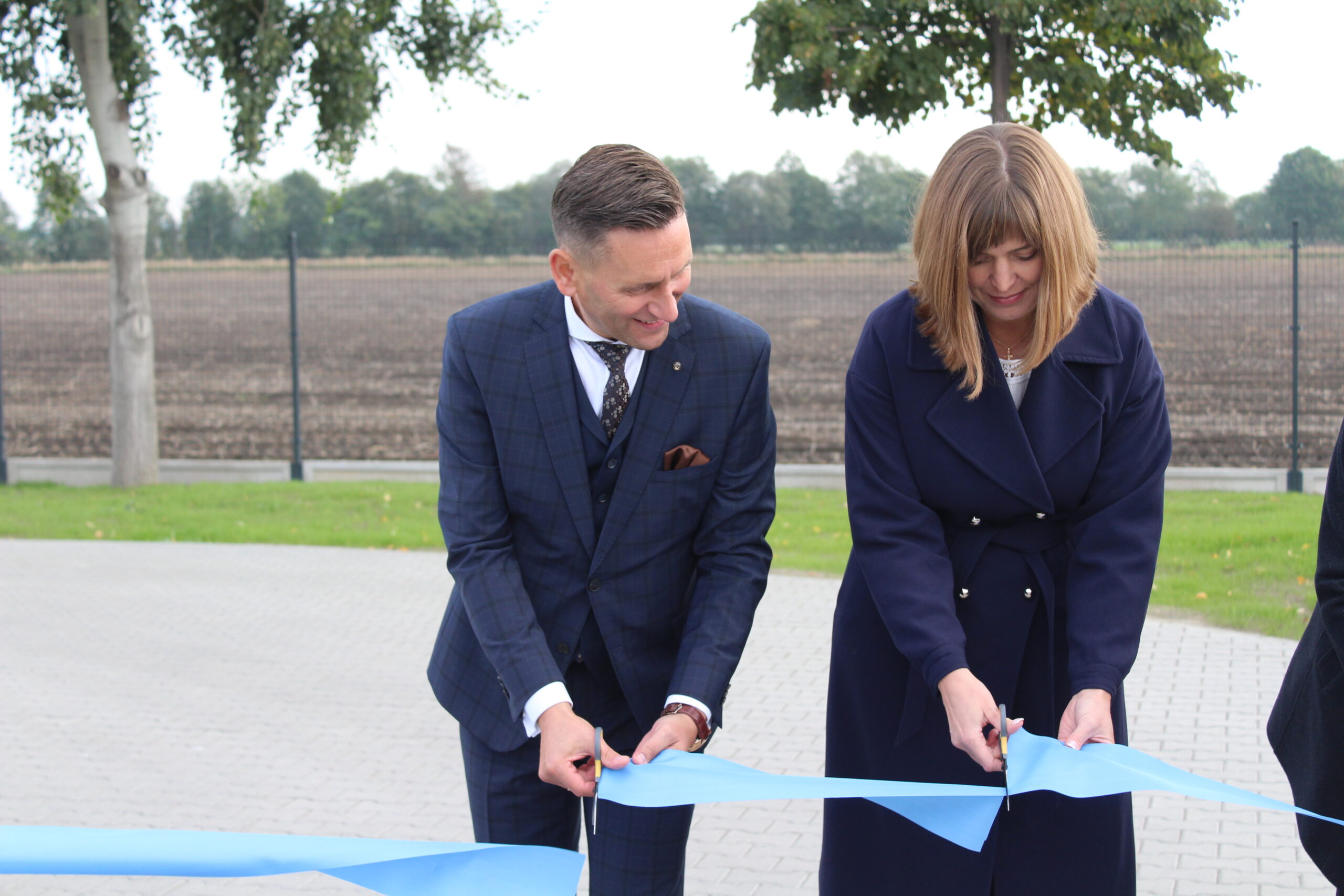 2 osoby przecinają wstęgę.