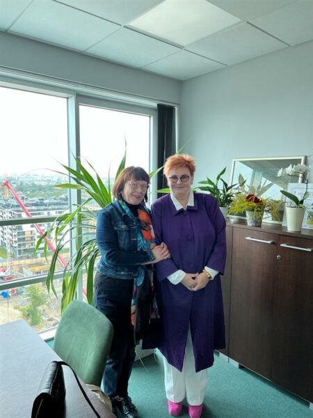 2 osoby stoją w pomieszczeniu.