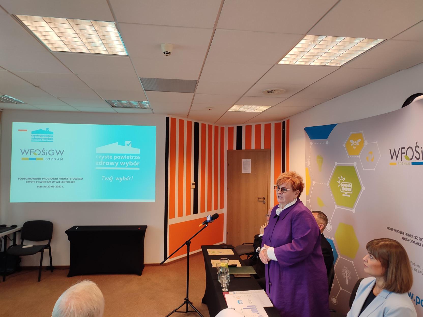 1 osoba stoi i przemawia.