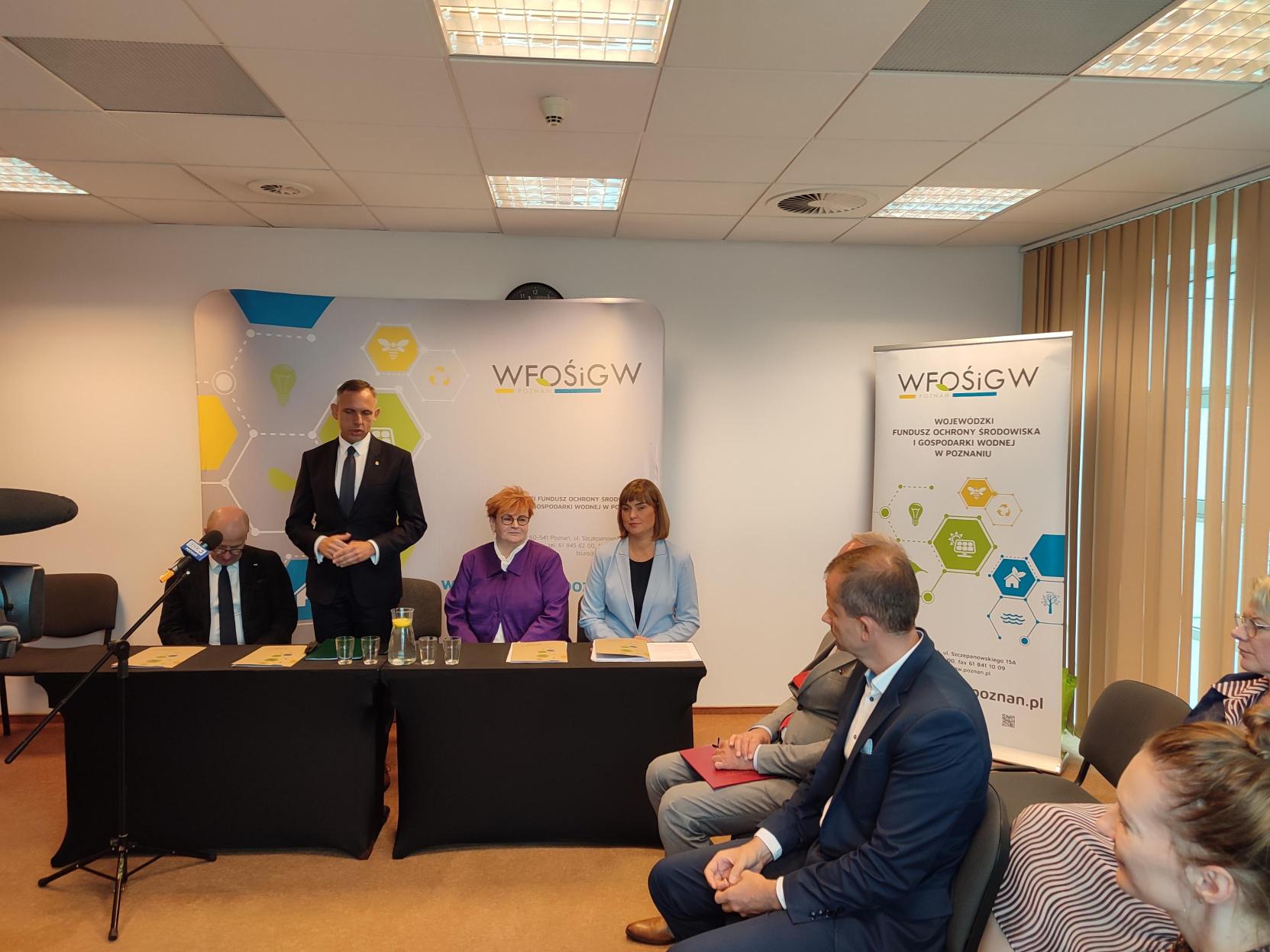 4 osoby siedzą za stołem.