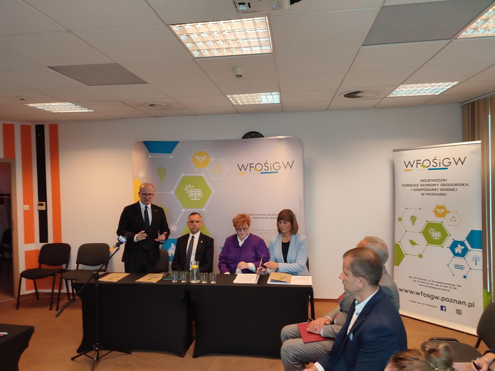 4 osoby siedzą za stołem.