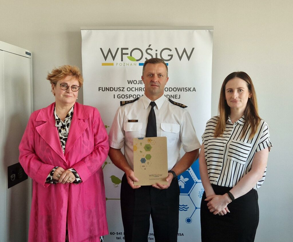 3 osoby stoją na tle ściany.