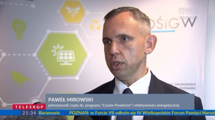 1 osoba stoi na tle ściany.