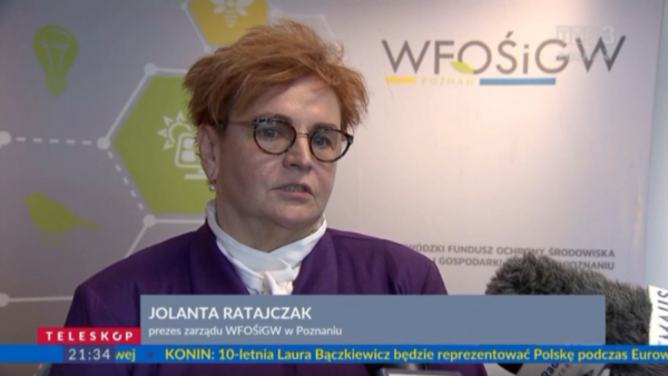 1 osoba stoi na tle ściany.