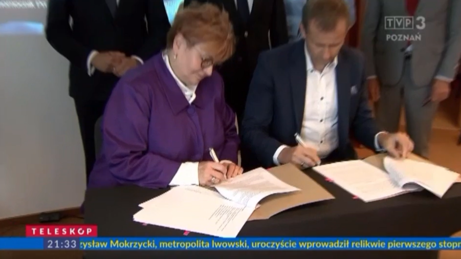 2 osoby siedzą przy stole.