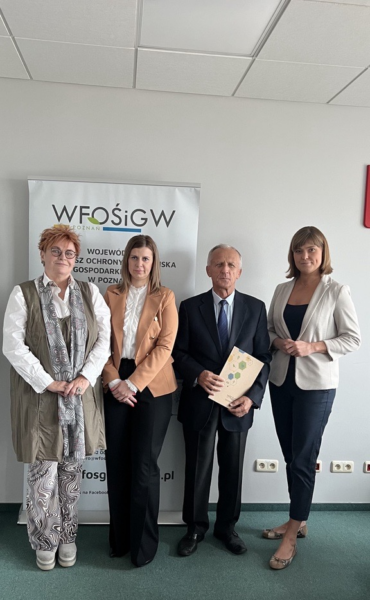 4 osoby stoją na tle ściany.