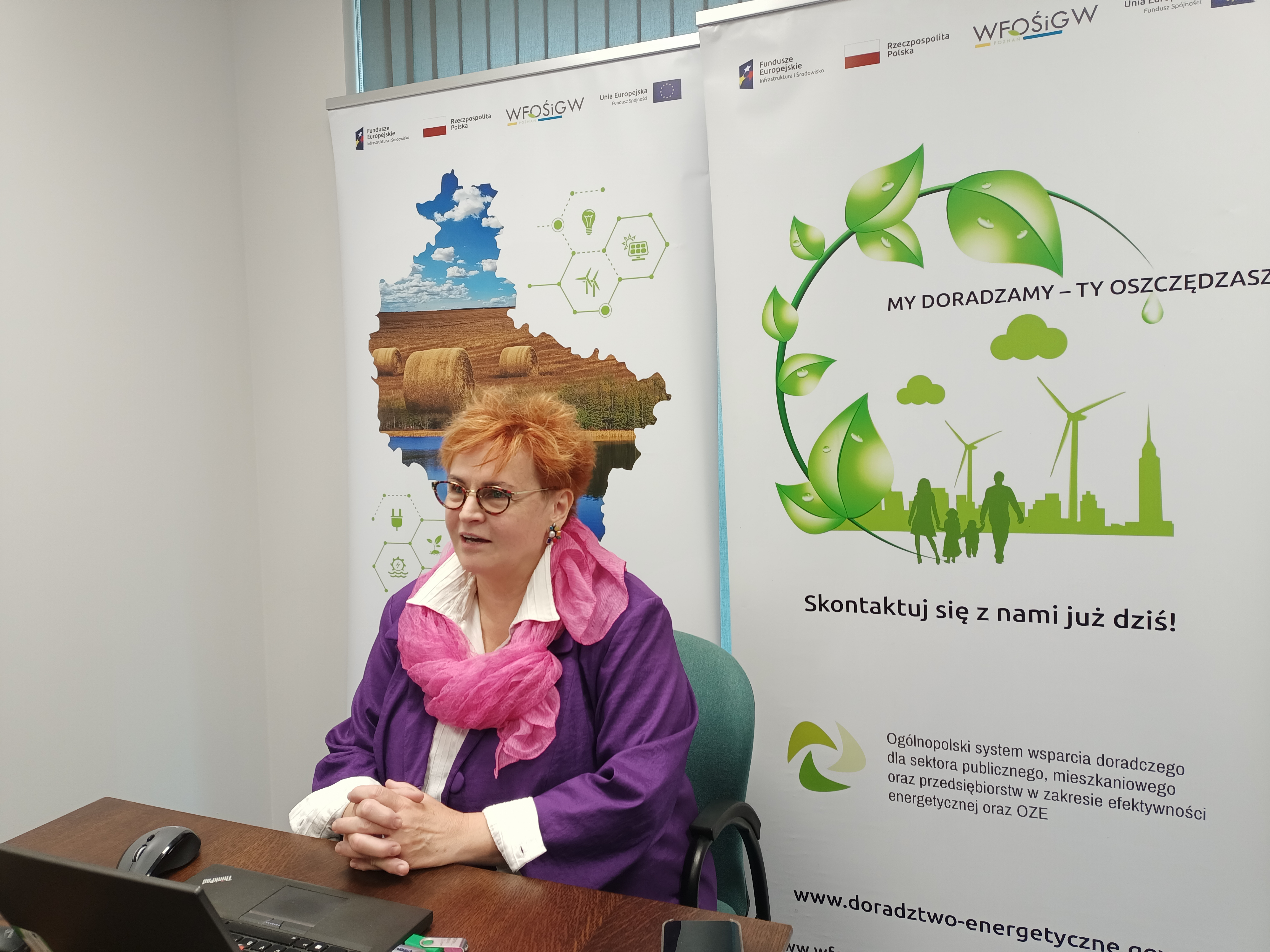 1 osoba siedzi przy biurku.