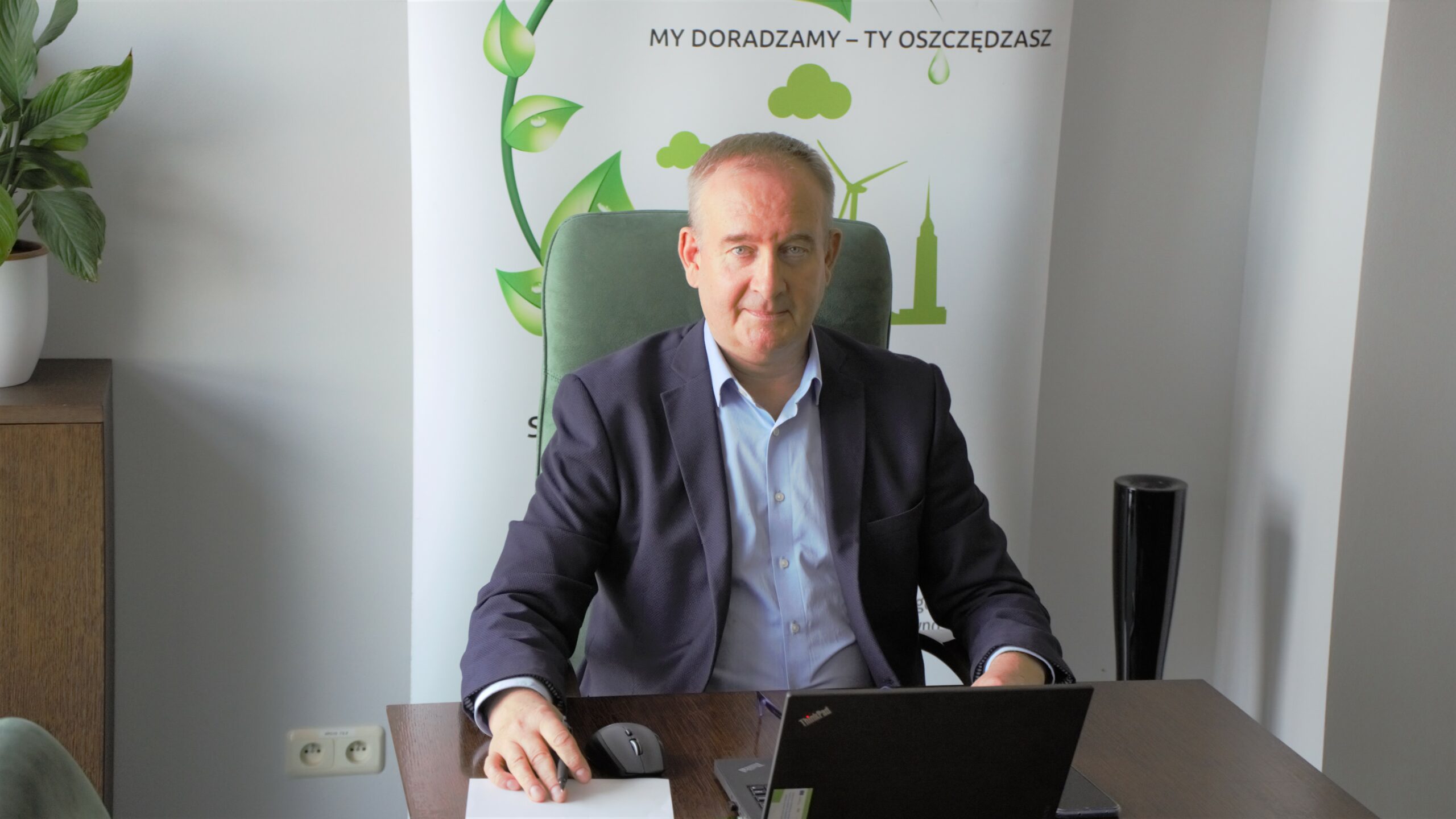 1 osoba siedzi za biurkiem.