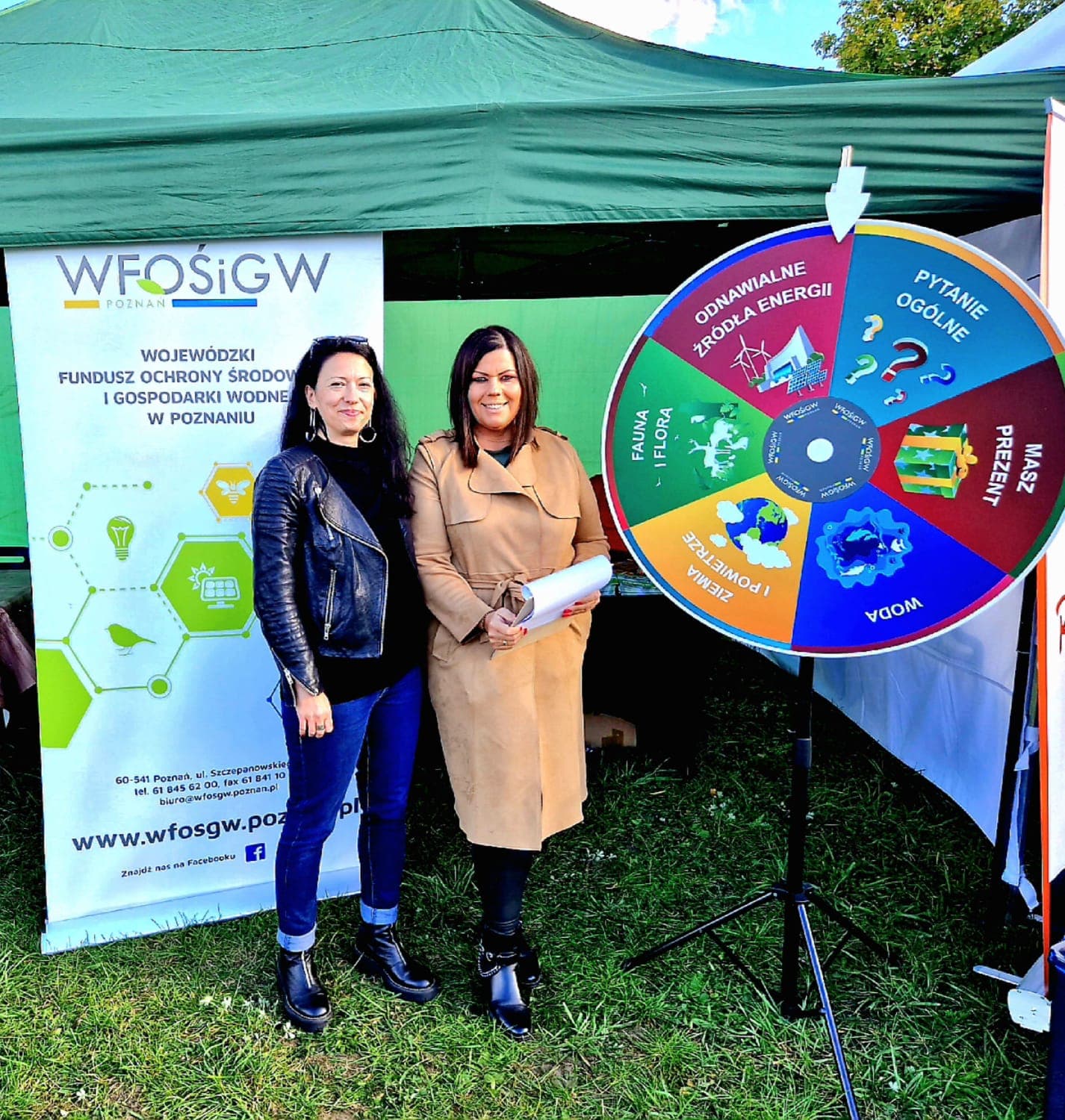 2 osoby stoją przy stoisku na festynie.