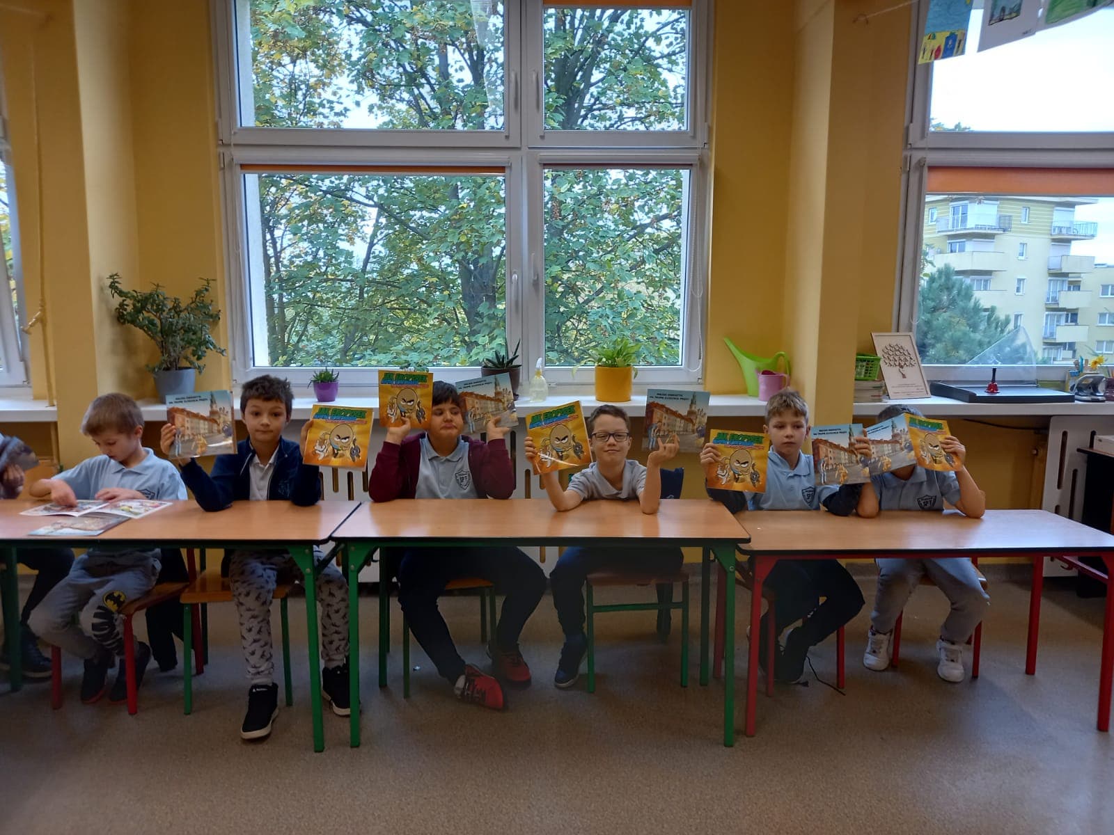 Sala lekcyjna z uczniami siedzącymi w ławkach.