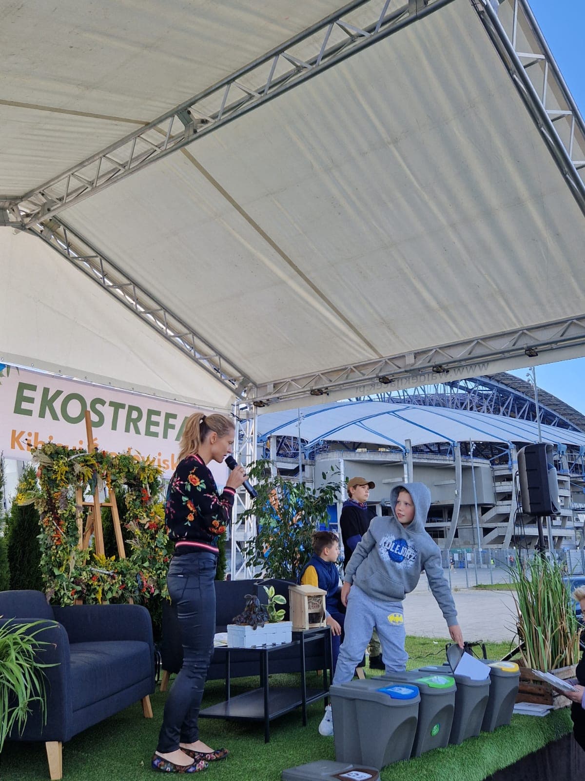 4 osoby stoją na scenie.