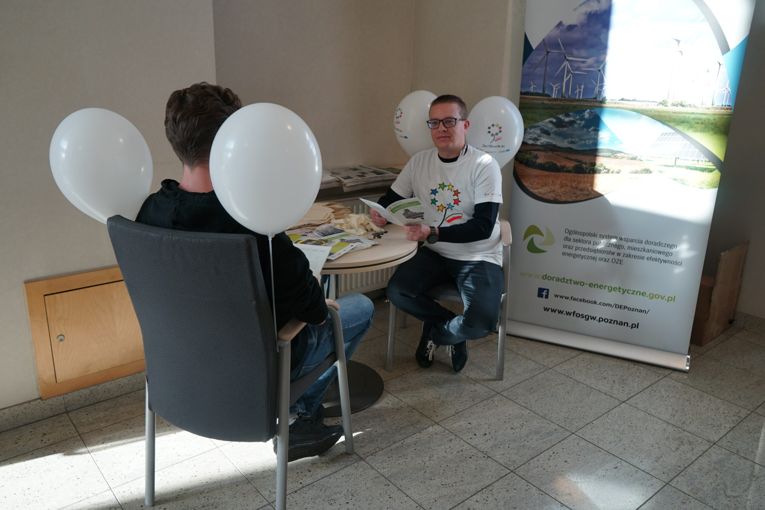 2 osoby siedzą przy stole.