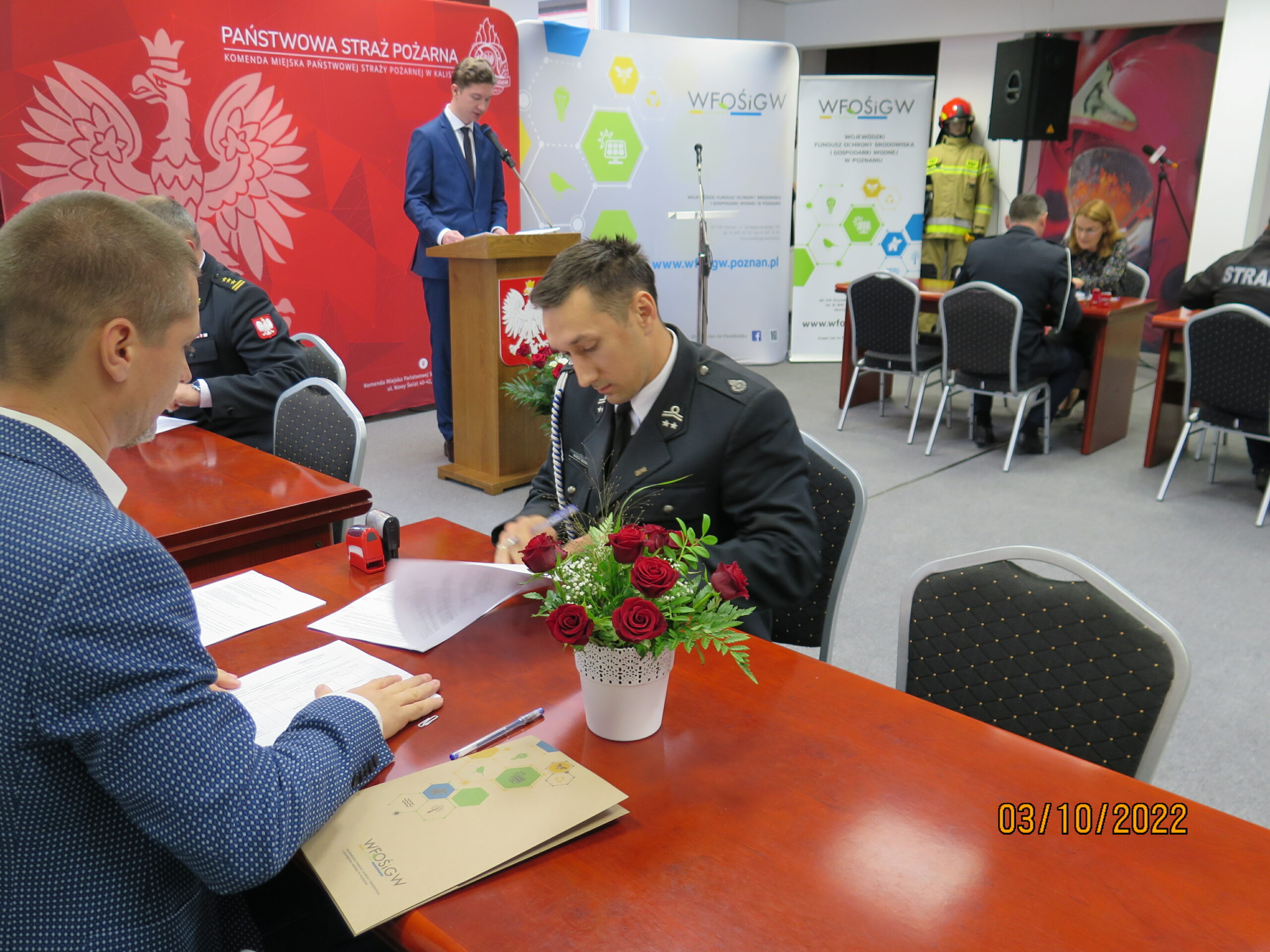 2 osoby siedzą przy stole.