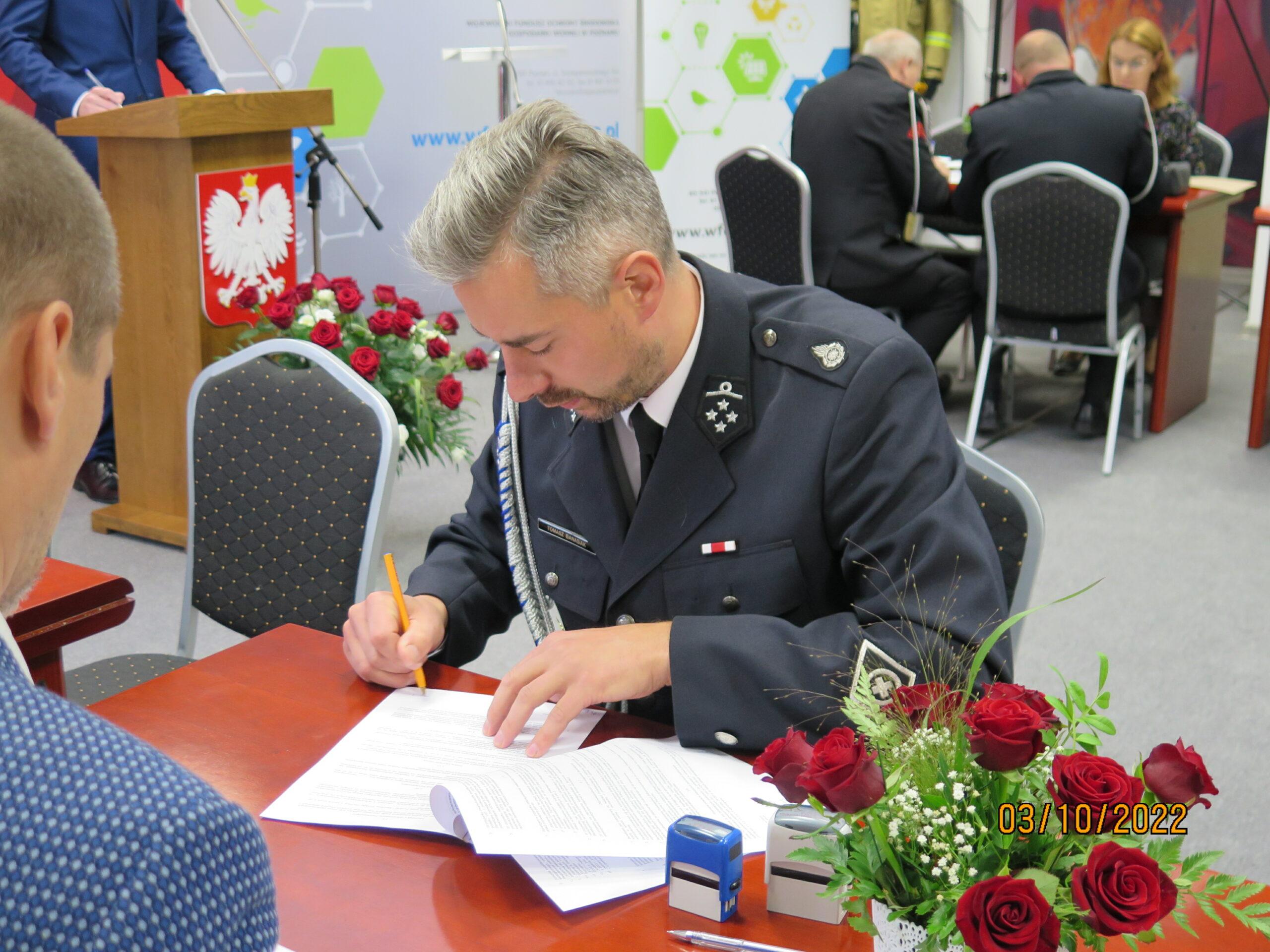 2 osoby siedzą przy stole.