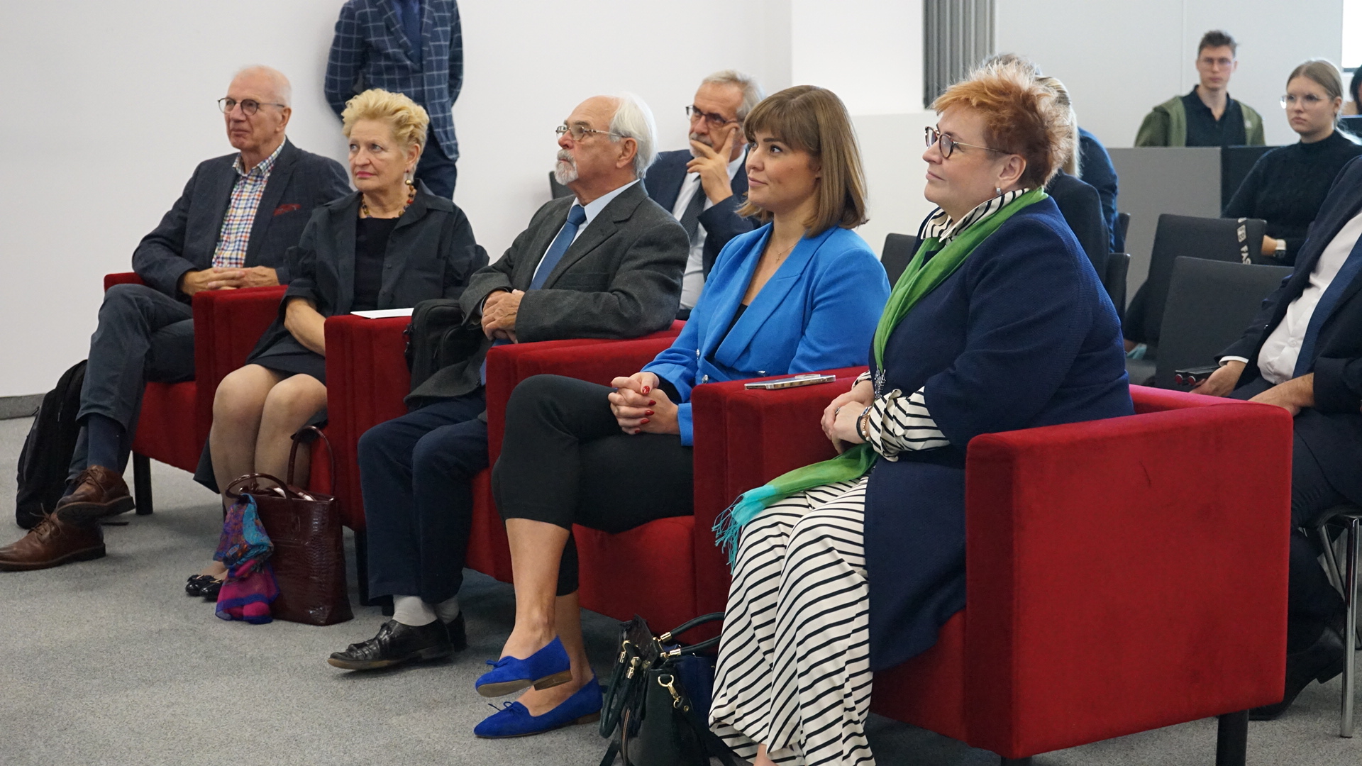 4 osoby siedzą na widowni.