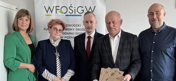 5 osób stoi na tle ściany.