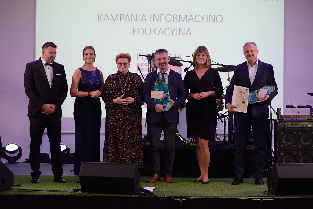 6 osób stoi na scenie.