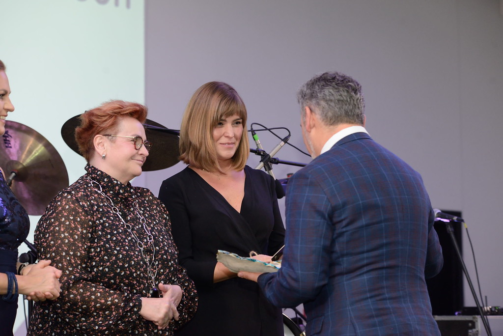 3 osoby stoją na scenie.