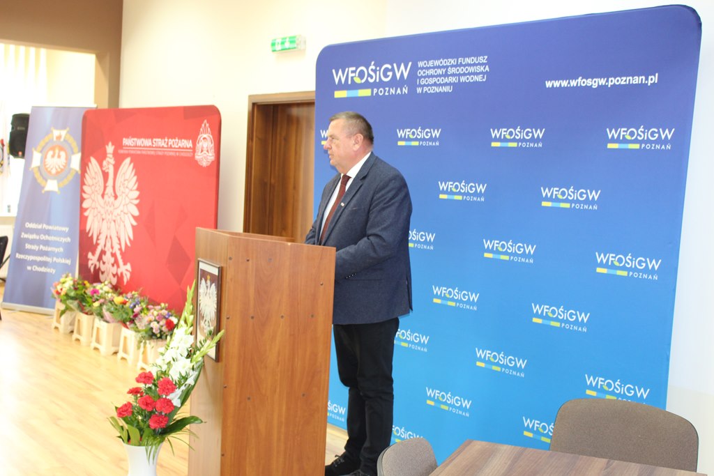 1 osoba stoi przy mównicy.