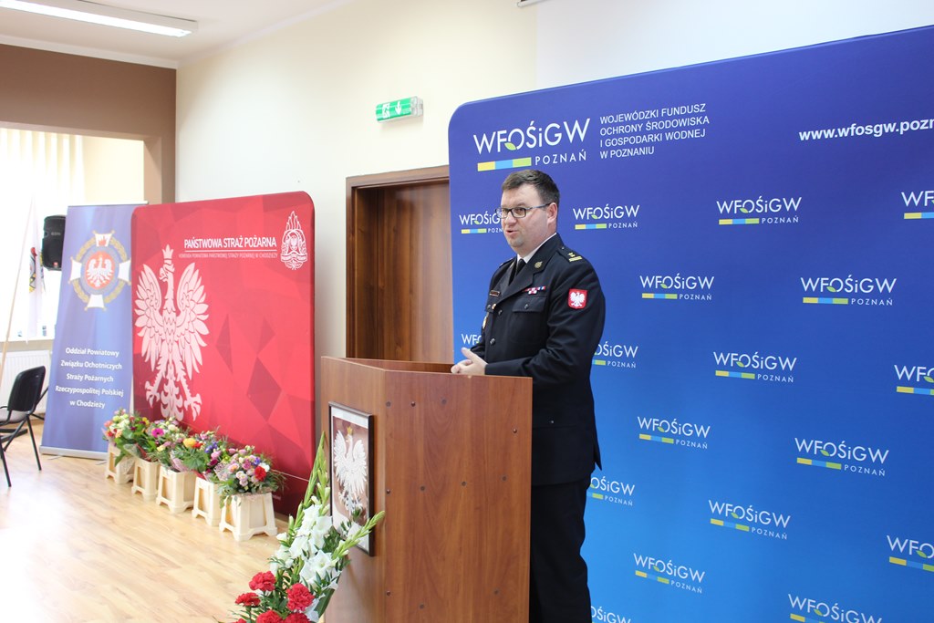 1 osoba stoi przy mównicy.