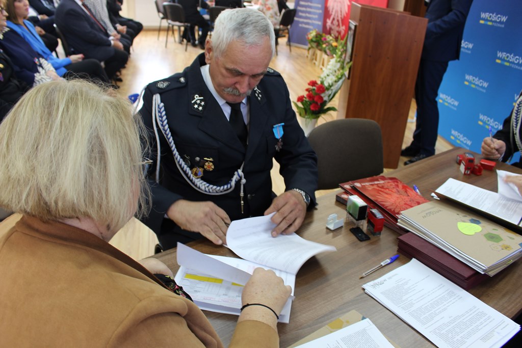 2 osoby siedzą przy stole.